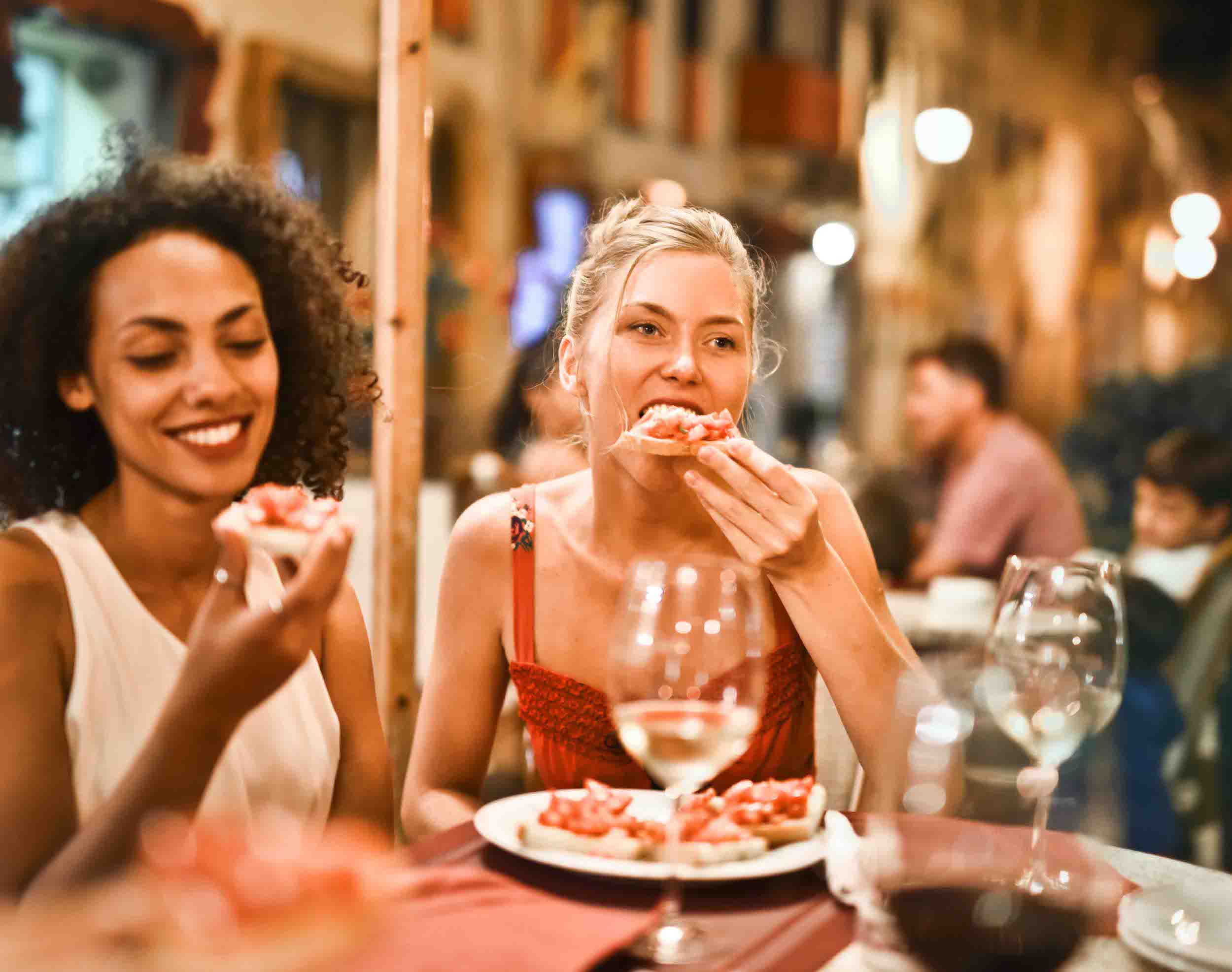 beautiful girls eating and enjoying food at restaurant